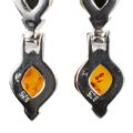 Close-up back view of 925 sterling silver hallmark on genuine Baltic amber earrings, showing “925” stamp and open-back honey amber stones on a white background.