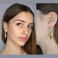 Model wearing genuine Baltic amber drop earrings in 925 sterling silver with multicolor amber stones, lightweight handcrafted earrings made in Poland
