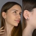 Woman wearing dual green and honey Baltic amber stud earrings in 925 sterling silver, oval two-stone post earrings shown on ear with natural amber inclusions