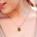 Woman wearing genuine Baltic honey amber pendant necklace in 925 sterling silver, Beaming Sun handmade Polish amber jewelry on 18 inch chain