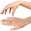 Two hands modeling a sterling silver ring with a rectangular genuine Baltic honey amber cabochon, shown from different angles to display fit, profile, and stone color.