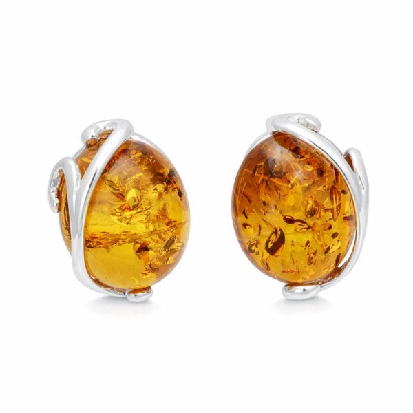 Close up of genuine Baltic honey amber earrings in 925 sterling silver, oval amber cabochon stones with natural inclusions, elegant minimalist silver setting, real amber jewelry for women